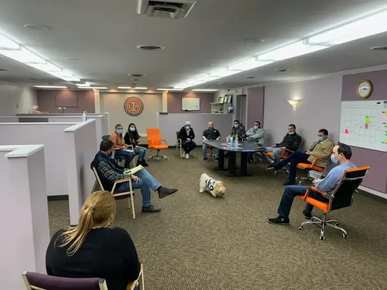 A group of people sitting in chairs and talking.