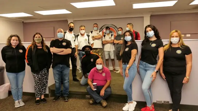 A group of people wearing masks in an office.